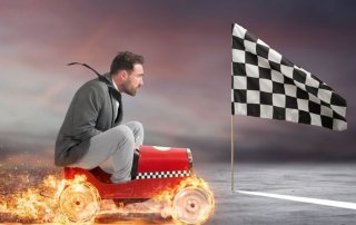 man on a small car heading towards a black and white flag